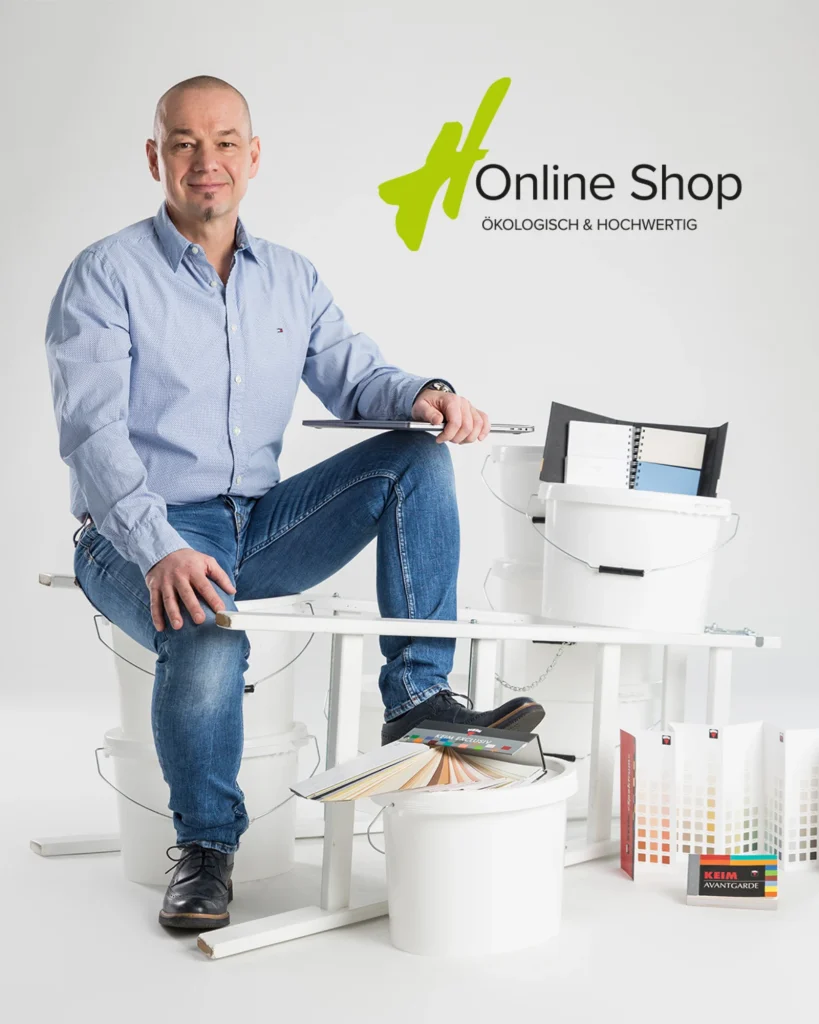Hannes Herbsthofer mit Laptop und Werkzeug und Aufschrift Online Shop