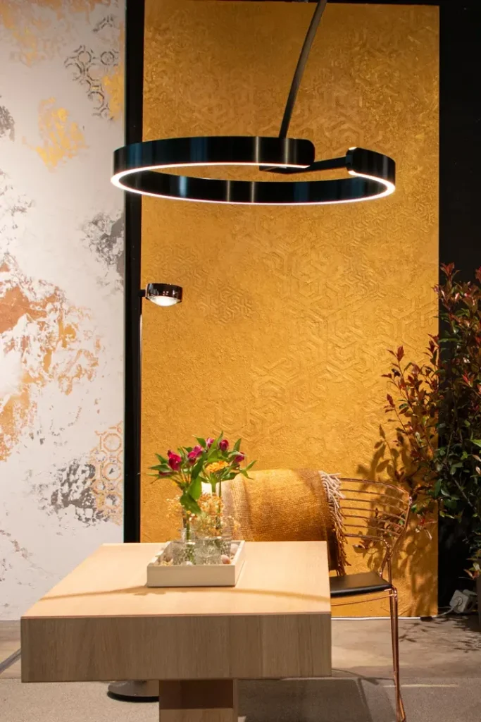 Bild einer goldenen atmenden Wand, mit Tisch und Sessel davor 