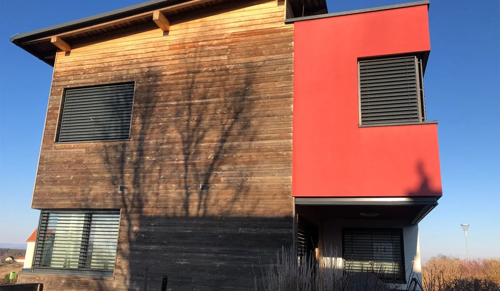 Haus mit roter Fassade und Holz Schalung