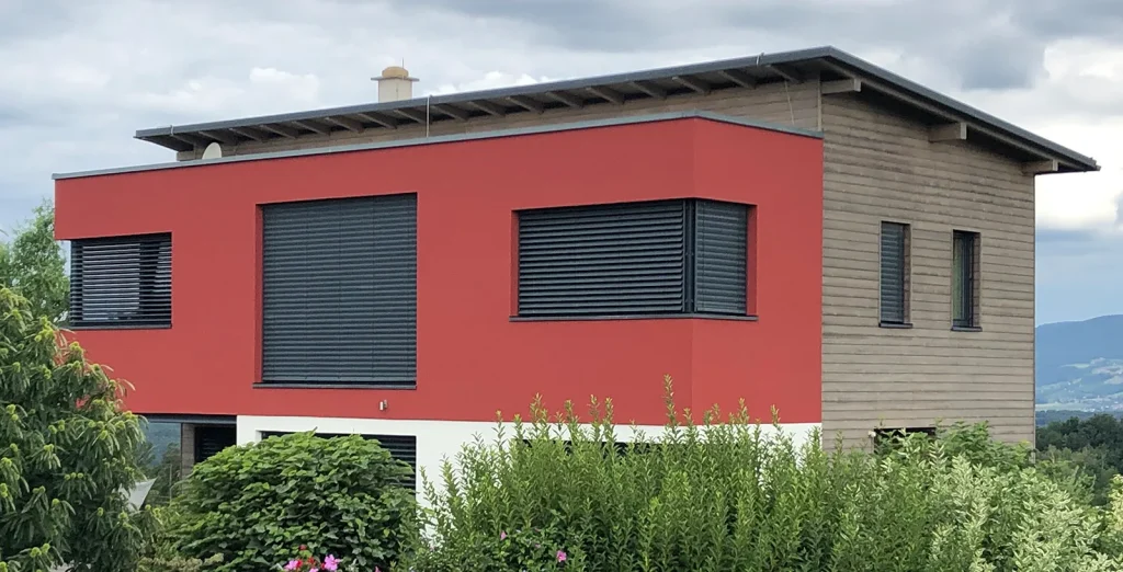 Haus mit roter Fassade und Holz Schalung