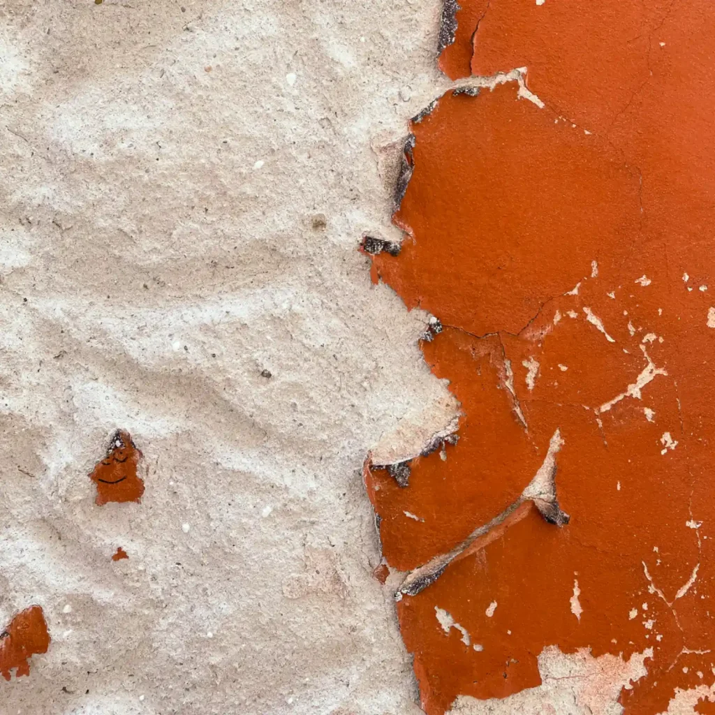 Rote Farbe löst sich von der Wand