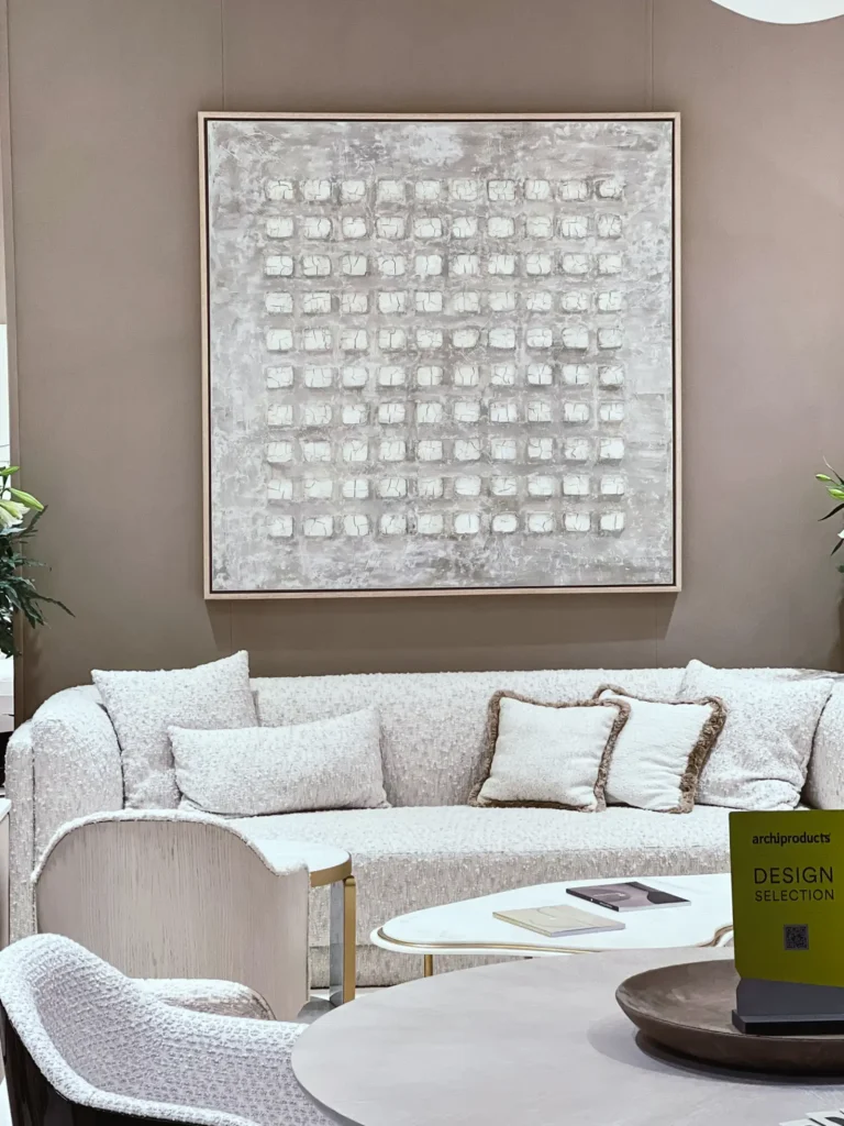 Ausschnitt eines Wohnraums mit weißer Couch und weiß - grauen Bildes im Hintergrund