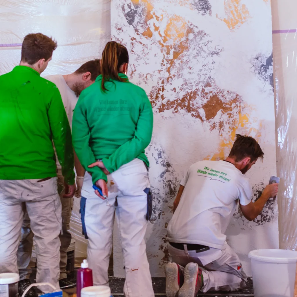 Mitarbeiter spachteln ein Muster auf eine Platte