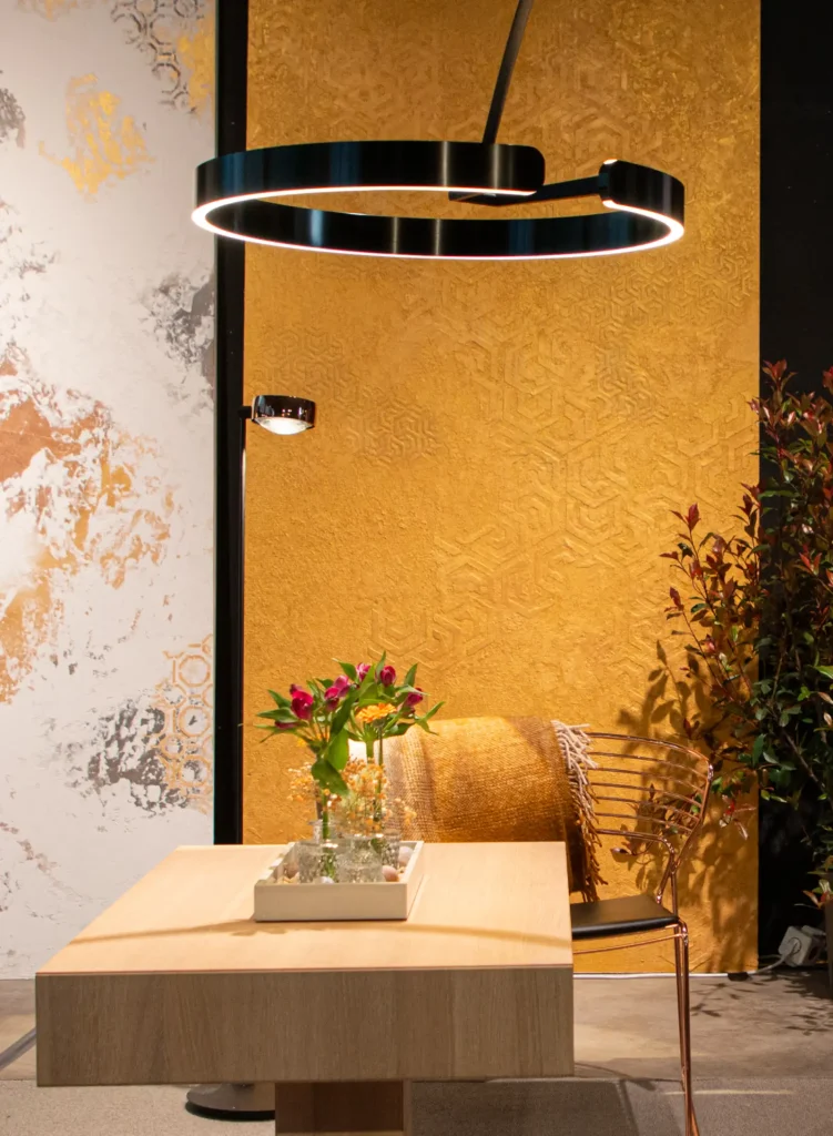 Tisch und Stuhl vor goldener atmender Wand