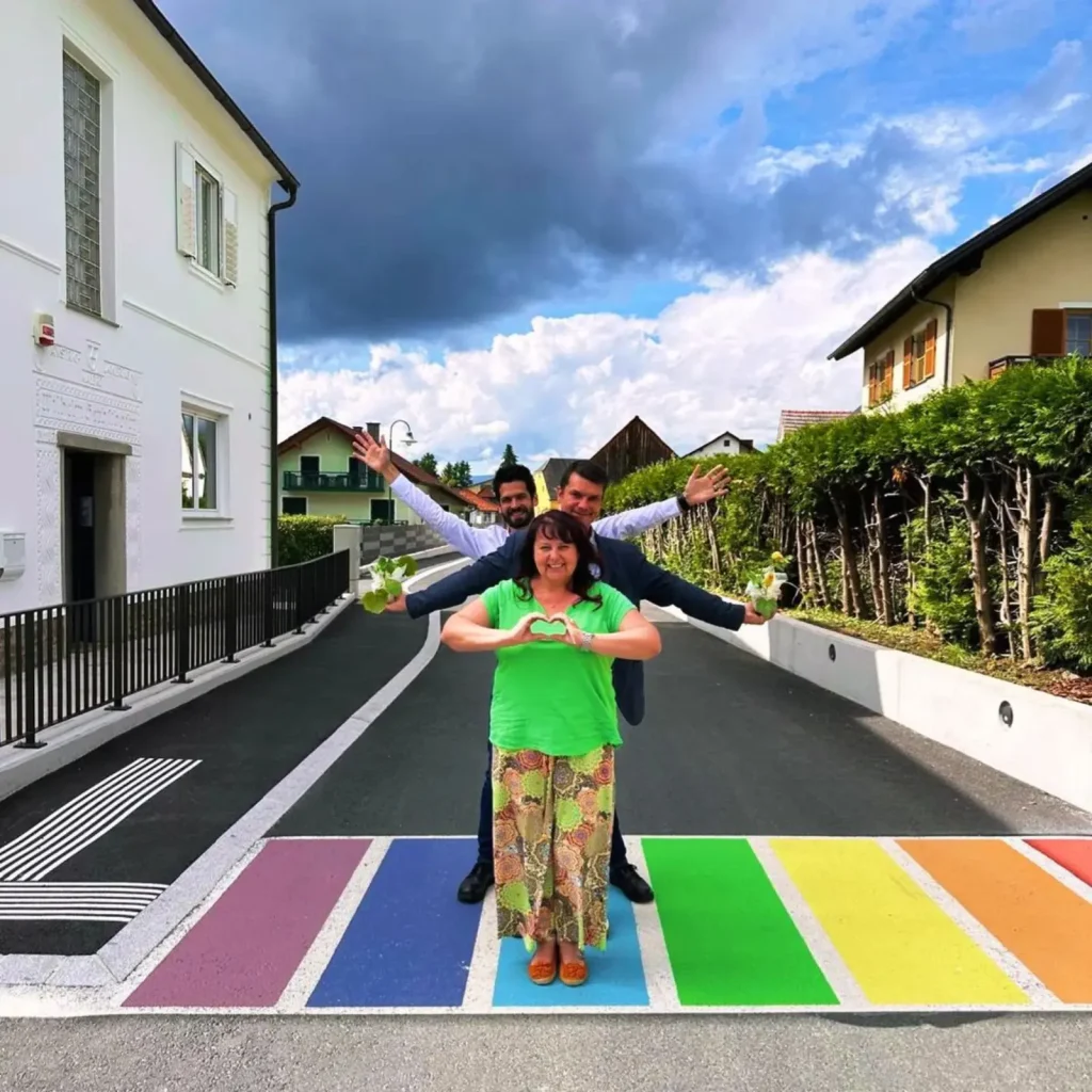 Drei Personen die eine Pose auf einen bunten Zebrastreifen machen