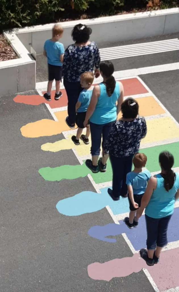 7 Personen die mit Abständen auf einen bunten Zebrastreifen stehen