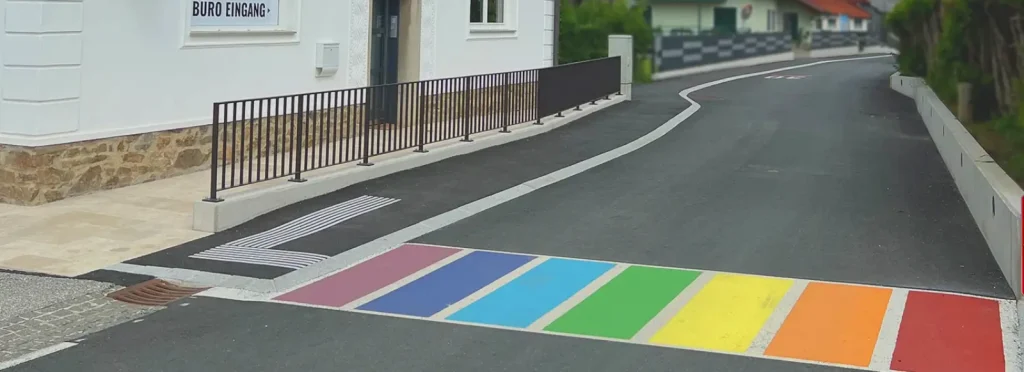 Ein Regenbogenfarbener Zebrastreifen der über eine Straße führt