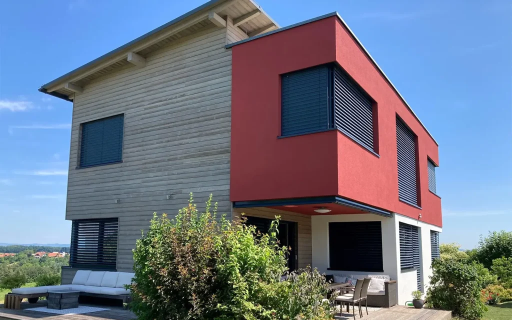 Haus mit roter Fassade und Holz Schalung