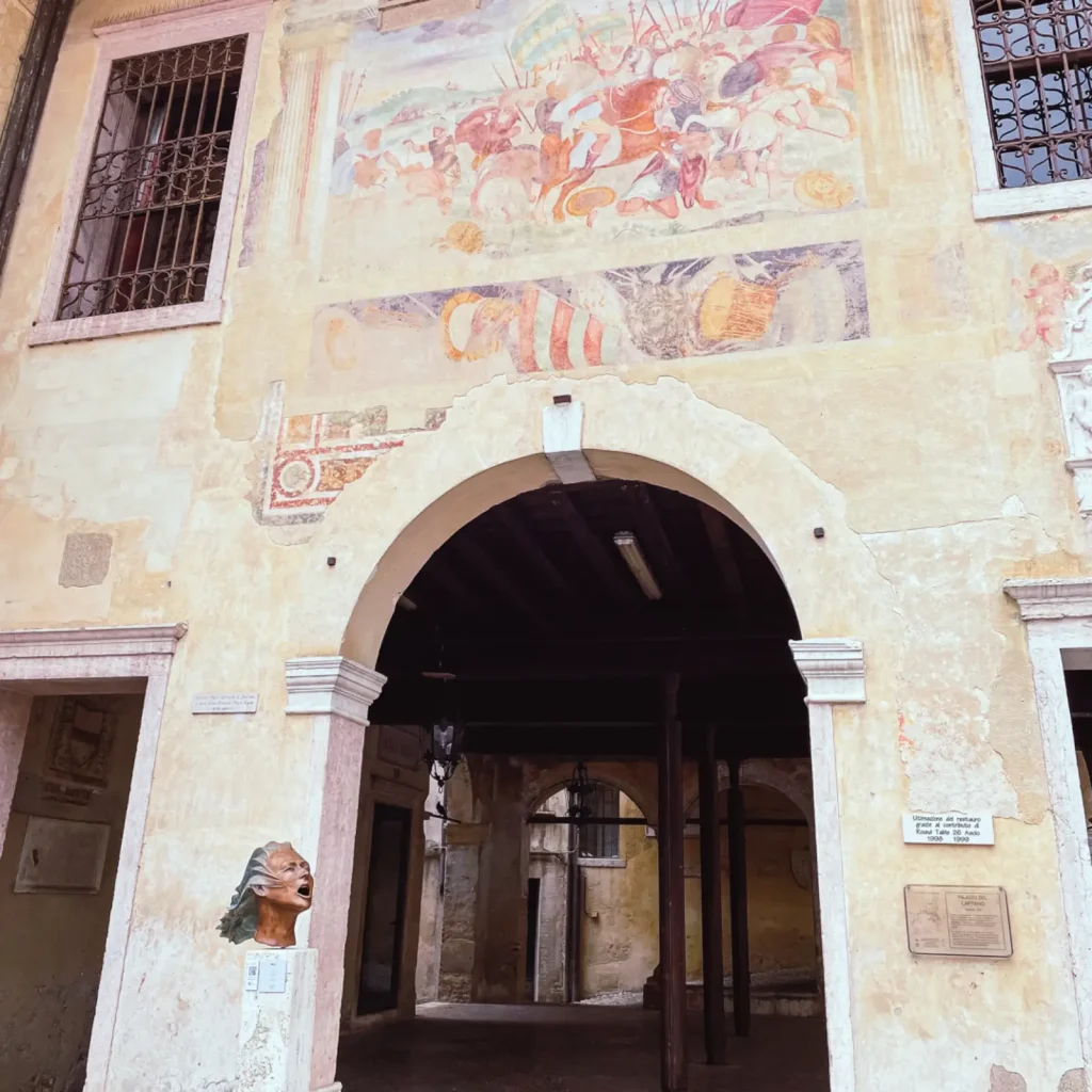 Altes Gebäude mit Statue (kopf einer Frau) im Vordergrund 
